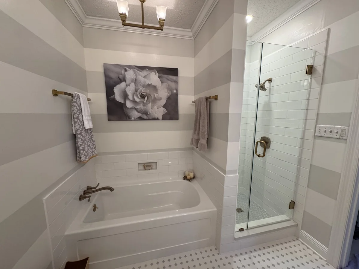 Renovated bathroom with a bathtub and glass shower